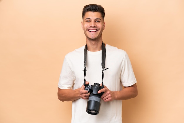 Jonge fotograaf blanke man geïsoleerd op beige achtergrond met de armen gekruist in frontale positie