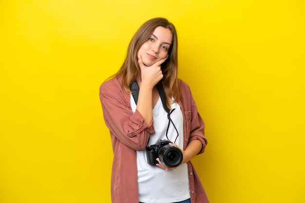 Jonge fotograaf blanke vrouw geïsoleerd op gele achtergrond lachend