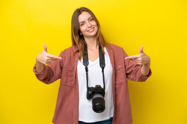 Jonge fotograaf blanke vrouw geïsoleerd op gele achtergrond trots en zelfvoldaan