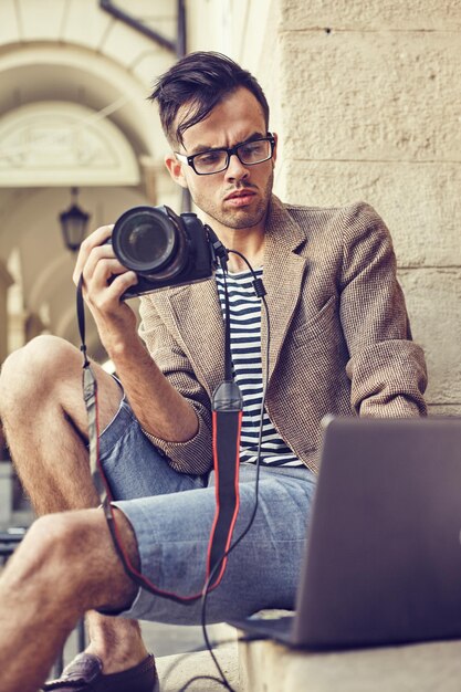 Jonge fotograaf die foto's bekijkt op een computer