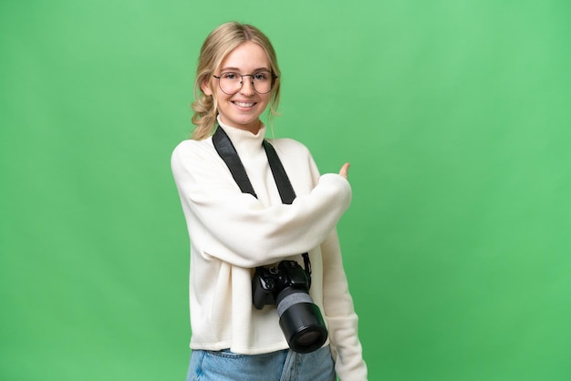 Jonge fotograaf Engelse vrouw over geïsoleerde achtergrond die terug wijst