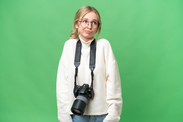 Jonge fotograaf Engelse vrouw over geïsoleerde achtergrond die twijfels gebaar maakt terwijl ze de schouders opheft