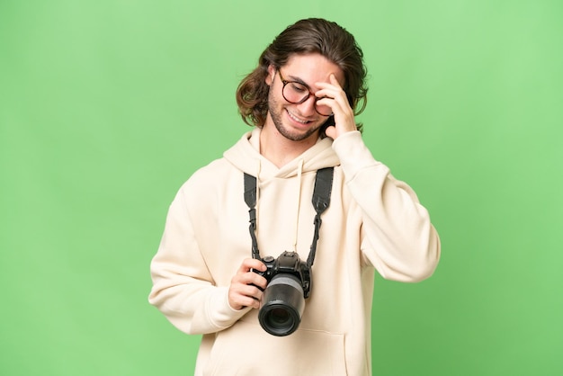 Jonge fotograaf man over geïsoleerde achtergrond lachen