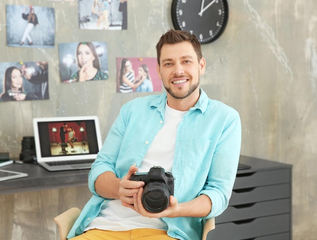 Jonge fotograaf met camera op kantoor