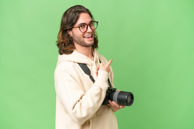 Jonge fotograafmens over geïsoleerde achtergrond die terug wijst