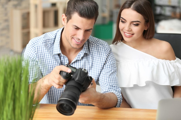 Jonge fotografen met camera op kantoor