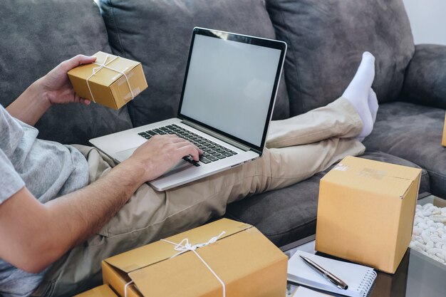 Jonge freelance man aan het werk met het verpakken van hun pakketten doos levering online markt