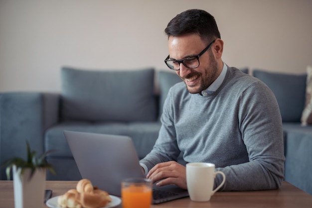 Jonge freelancer die op laptop werkt vanuit thuiskantoor