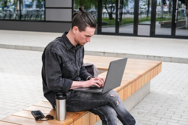 jonge freelancer werkt op een laptop in de stad Online zaken freelance Training en opleiding