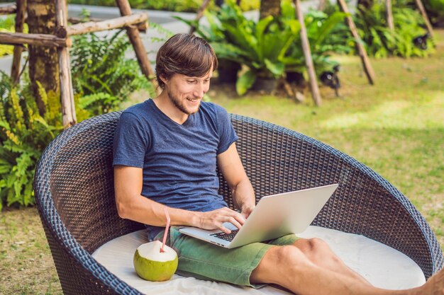 Jonge freelancer werkt op vakantie naast het zwembad.