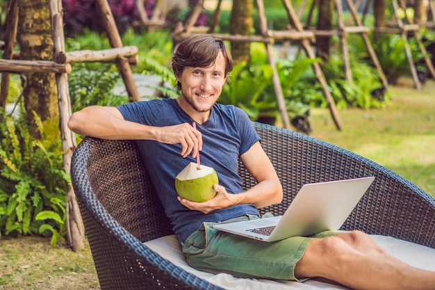 Jonge freelancer werkt op vakantie naast het zwembad.