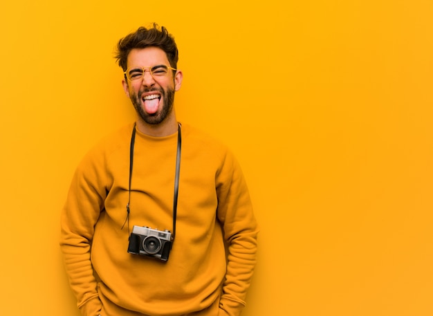 Jonge funnny van de fotograafmens en vriendschappelijke tonende tong