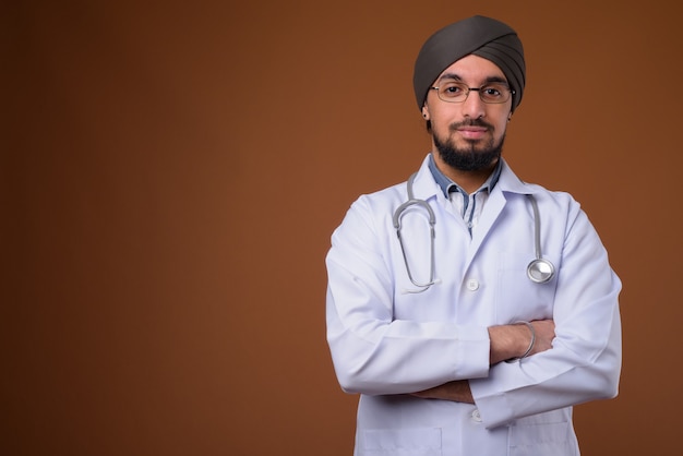 Jonge, gebaarde Indiase Sikh-arts die tulband draagt