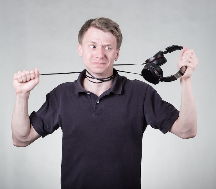 Foto jonge gefrustreerde man met een koptelefoon geïsoleerd