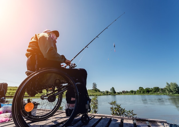 Jonge gehandicapte man in een rolstoel vissen