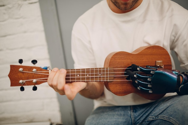 Jonge gehandicapte man met kunstmatige handprothese speelt op gitaar in de winkel