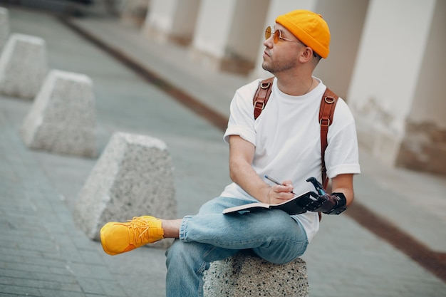 Jonge gehandicapte man schrijft in notitieboekje met pen in kunstmatige prothetische hand