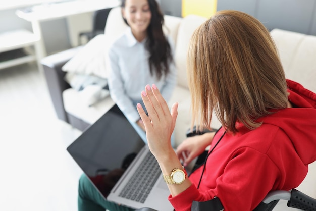 Jonge gehandicapte vrouw met laptop op schoot