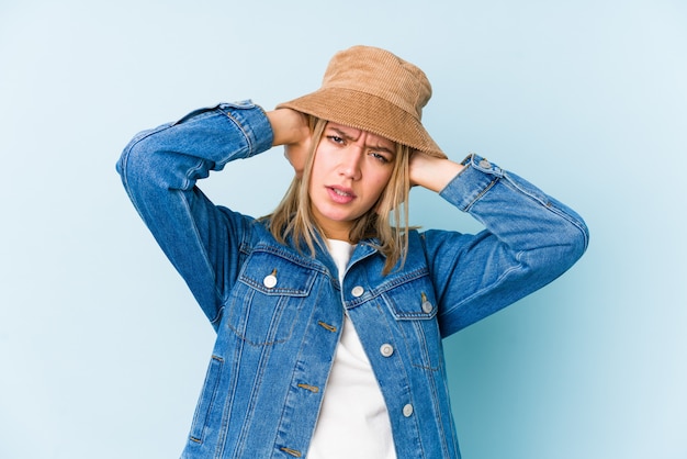 Jonge geïsoleerde blonde Kaukasische vrouw behandelend oren met handen die niet te hard geluid proberen te horen.