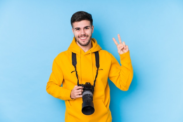 Jonge geïsoleerde fotograafmens tonend nummer twee met vingers