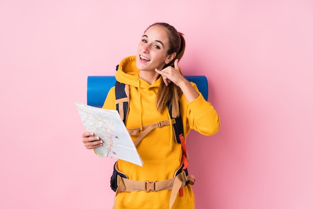 Jonge geïsoleerde reizigers Kaukasische vrouw tonend een mobiel telefoongesprekgebaar met vingers.