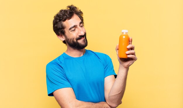 Jonge gekke bebaarde atleet gelukkige uitdrukking en met een smoothy