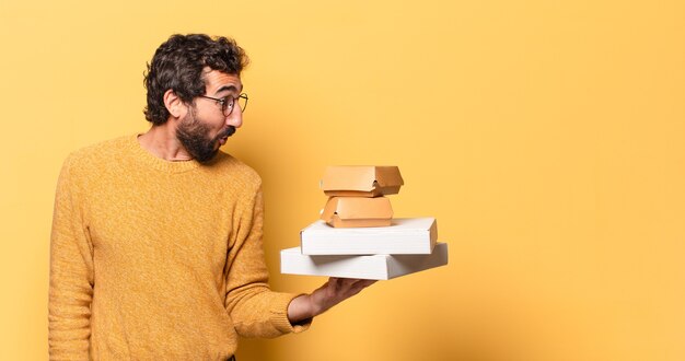 jonge gekke bebaarde man die fastfood heeft weggehaald met een kopieerruimte