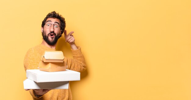 Jonge gekke bebaarde man die fastfood heeft weggehaald met een kopieerruimte