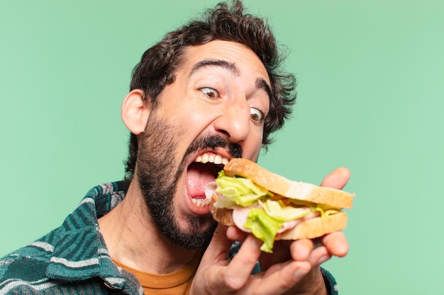 Jonge gekke bebaarde man gelukkige uitdrukking en met een broodje