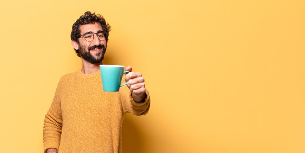 Jonge gekke bebaarde man met een koffiekopje