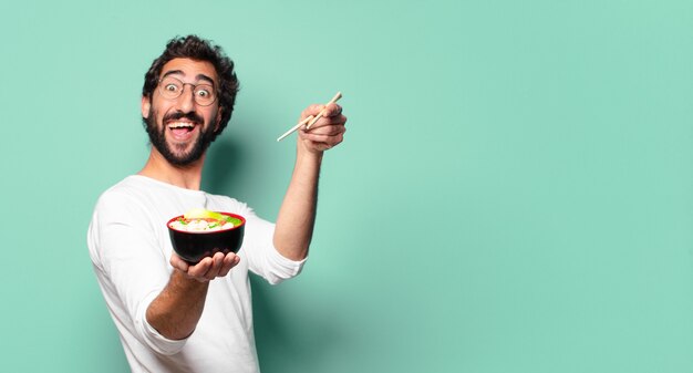 Jonge gekke bebaarde man met een noodle ramen bowl ramen