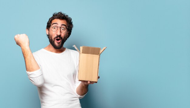 Jonge gekke bebaarde man recibing een kartonnen pakket