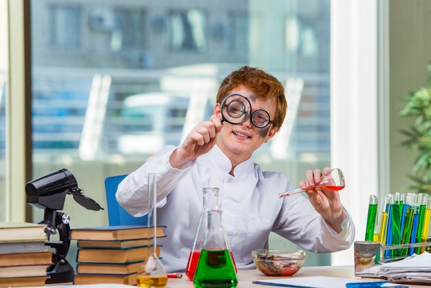 Jonge gekke chemicus die in het laboratorium werkt