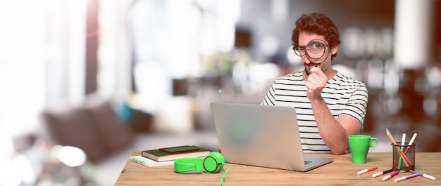 Foto jonge gekke grafische ontwerper op een bureau met laptop