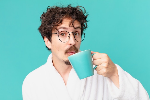 Jonge gekke man met een kopje koffie