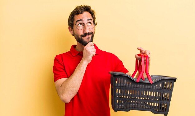 Jonge gekke man met een leeg winkelmandje