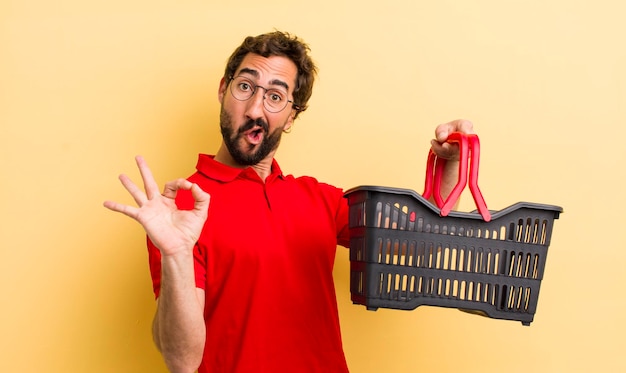 Jonge gekke man met een leeg winkelmandje