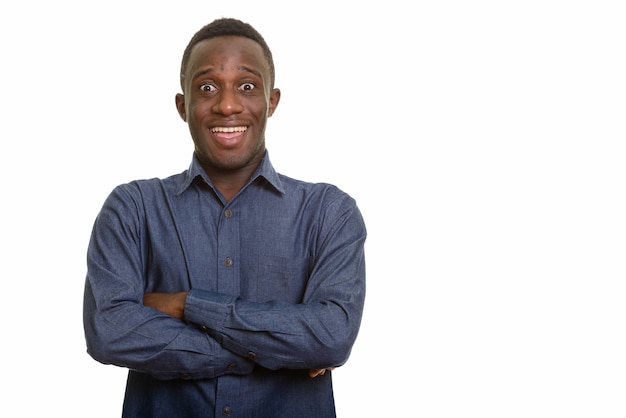 Jonge gelukkig Afrikaanse man lacht en kijkt opgewonden met gekruiste armen