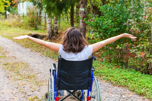 Jonge gelukkig handicap vrouw in rolstoel op weg in ziekenhuis park genieten van vrijheid