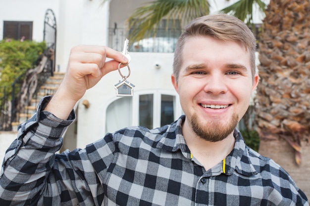 Jonge gelukkig man met een huissleutel