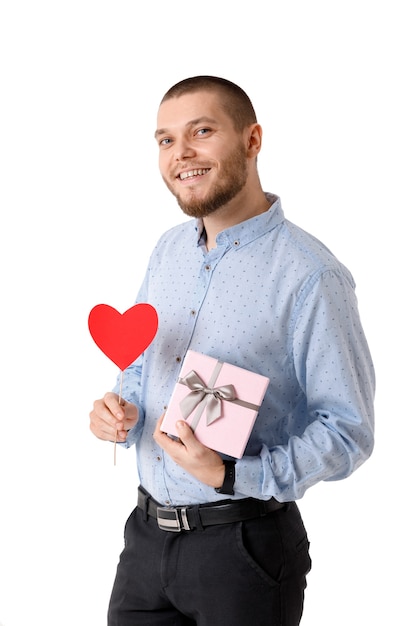 Jonge gelukkig man met rood papier hart en geschenkdoos geïsoleerd op een witte achtergrond