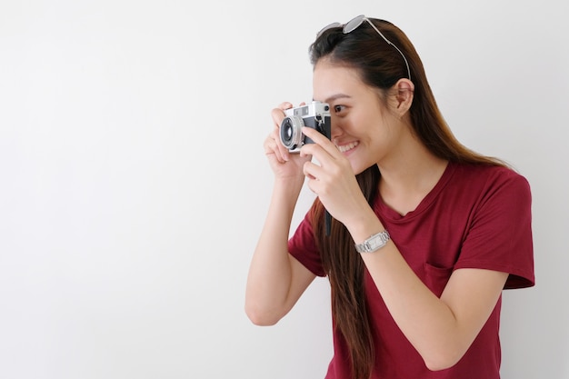 Jonge gelukkige Aziatische de holdingscamera die van de vrouwentoerist, Aziatisch reizigersmeisje glimlachen terwijl het houden van uitstekende camera op vakantie