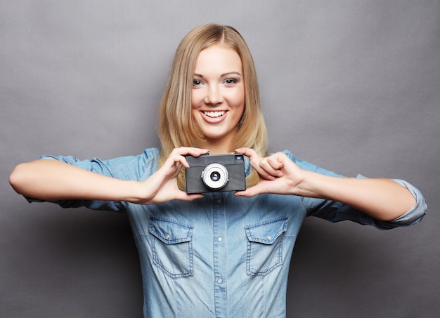 Jonge gelukkige blonde vrouw met uitstekende camera