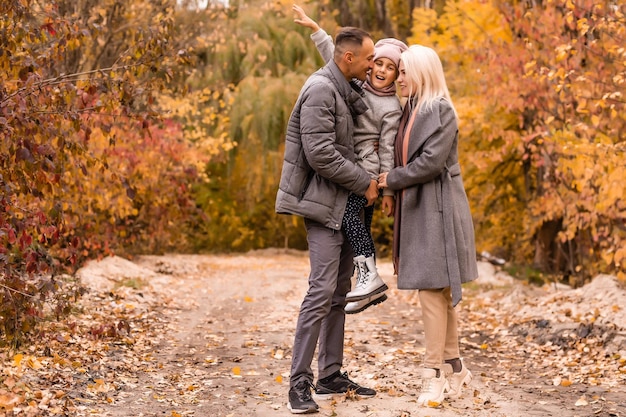 Jonge gelukkige familie tijdens het wandelen in het herfstpark.