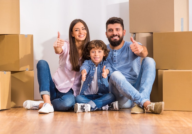 Jonge gelukkige familie verhuizen naar een nieuw huis, dozen openen.