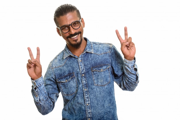Jonge gelukkige Indische mens die geïsoleerd vredesteken geeft