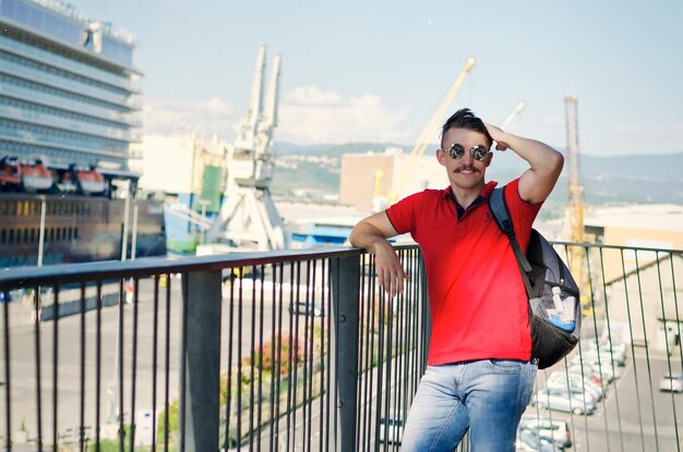 Jonge gelukkige knappe bebaarde man, toerist wandelen in de stad Koper. Zee haven. Cruise schip. Vakantie