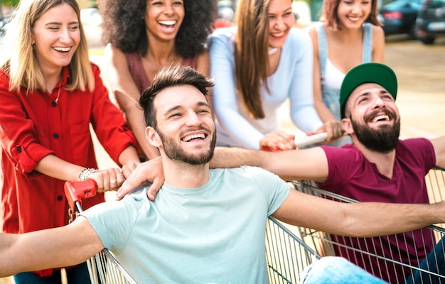 Jonge gelukkige mensen die samen plezier hebben op winkelwagentjes