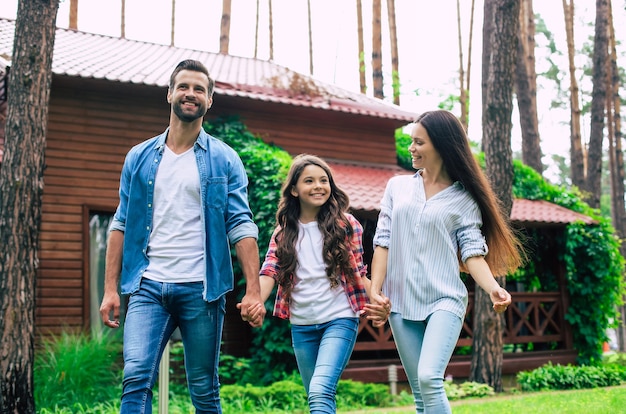 Jonge gelukkige moderne ouders met een schattige dochter lopen buiten