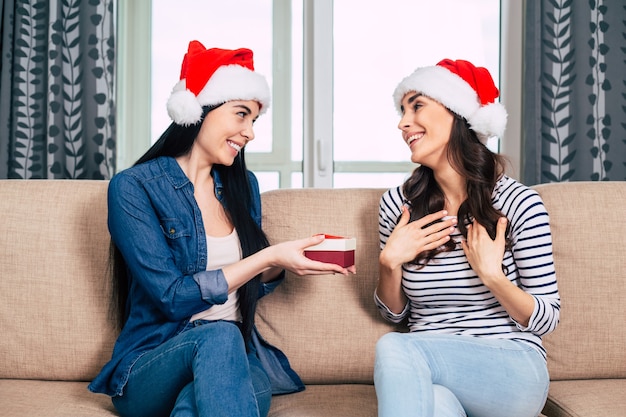 Jonge gelukkige mooie vrouwen in Kerstmanhoeden